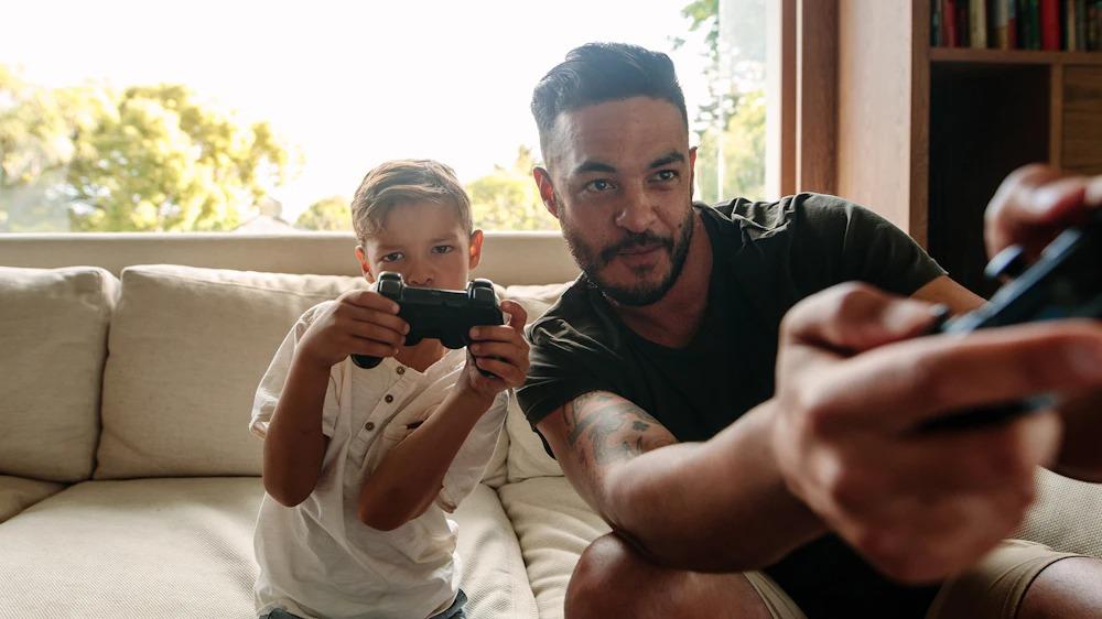 Father and son with controllers compete on video game