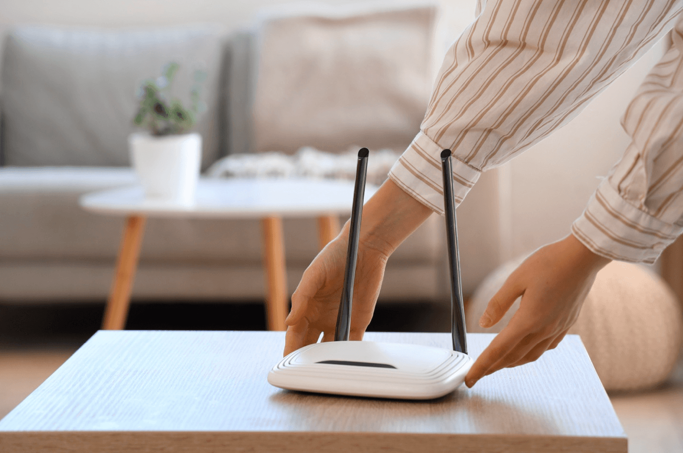 Hands placing a Wi-Fi router on a table