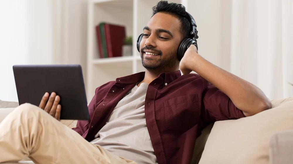 Man wears headsets and views his tablet streaming wirelessly
