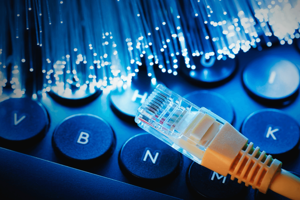 Fiber optic internet cables and ethernet cable on top of a keyboard