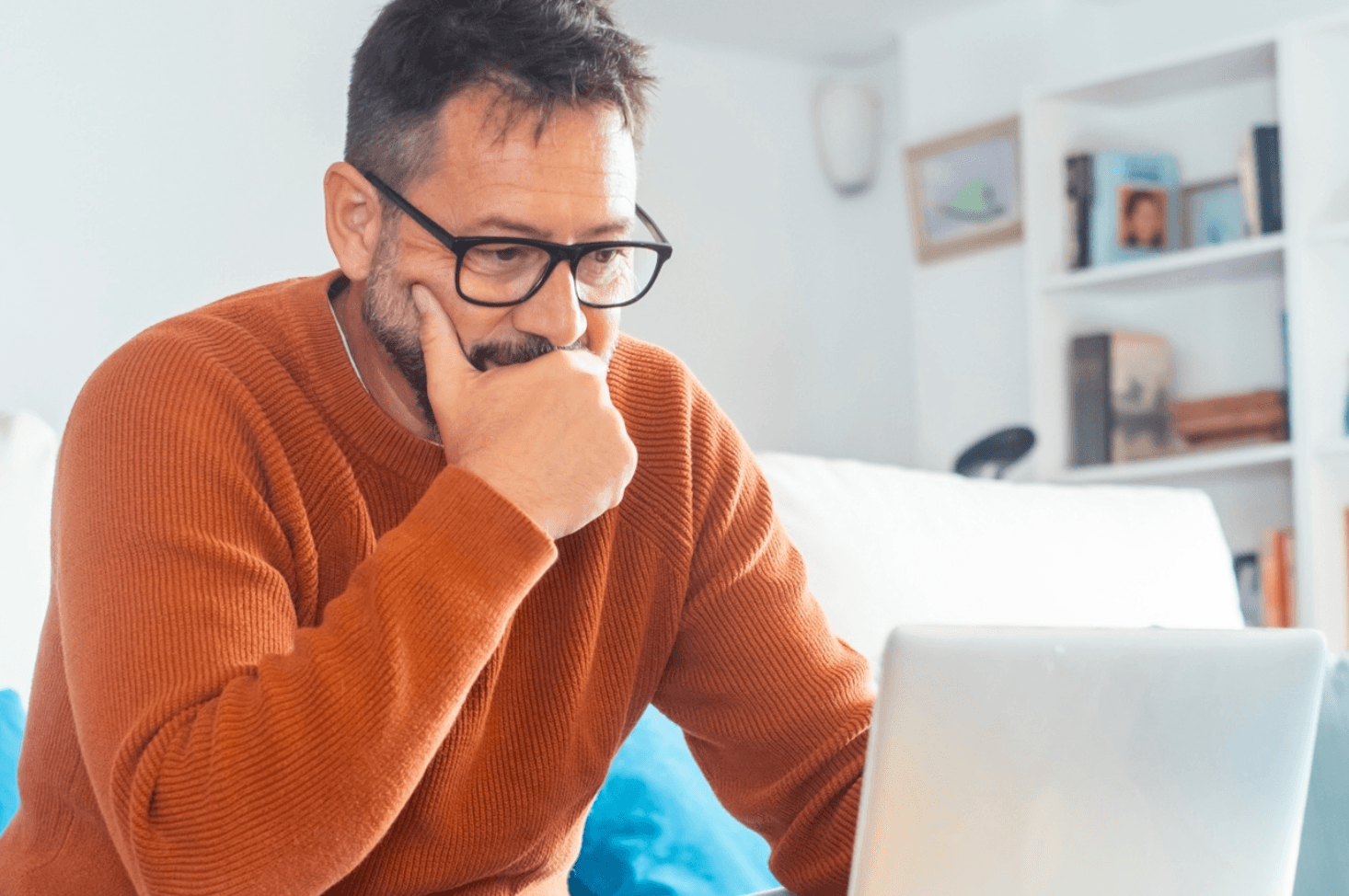 Inquisitive man looks at his laptop