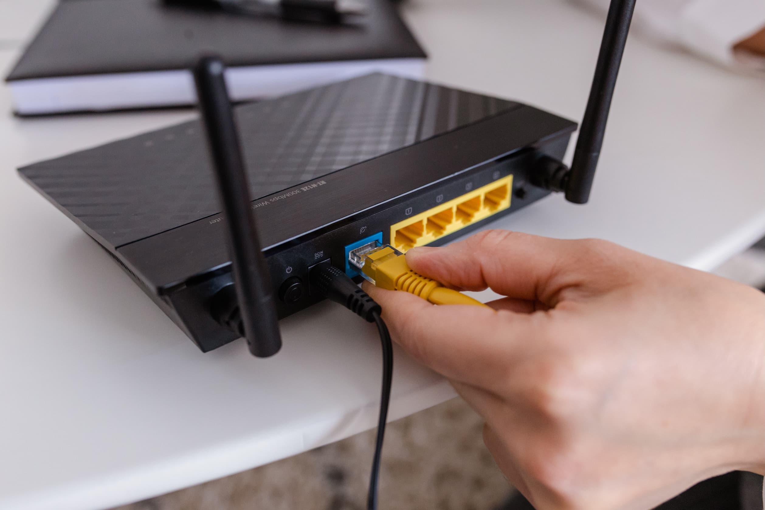blog/Person plugging in ethernet cable to internet router