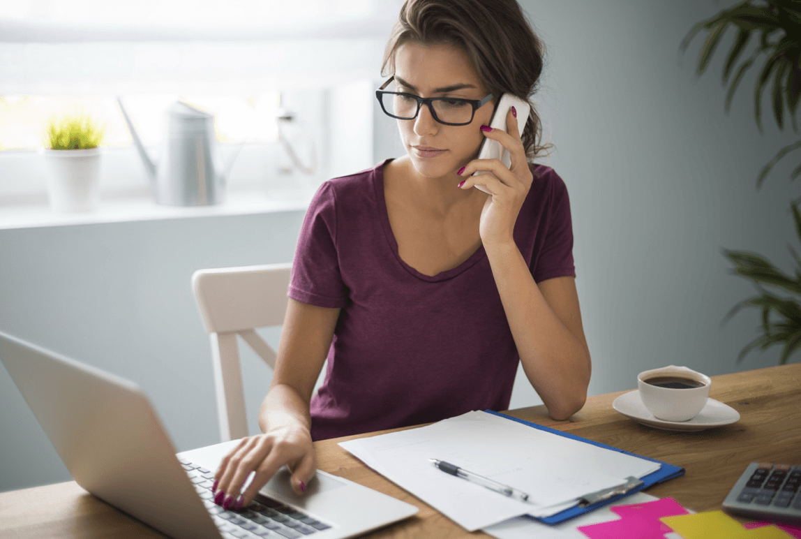 blog/Woman on phone and laptop at the kitchen table.png