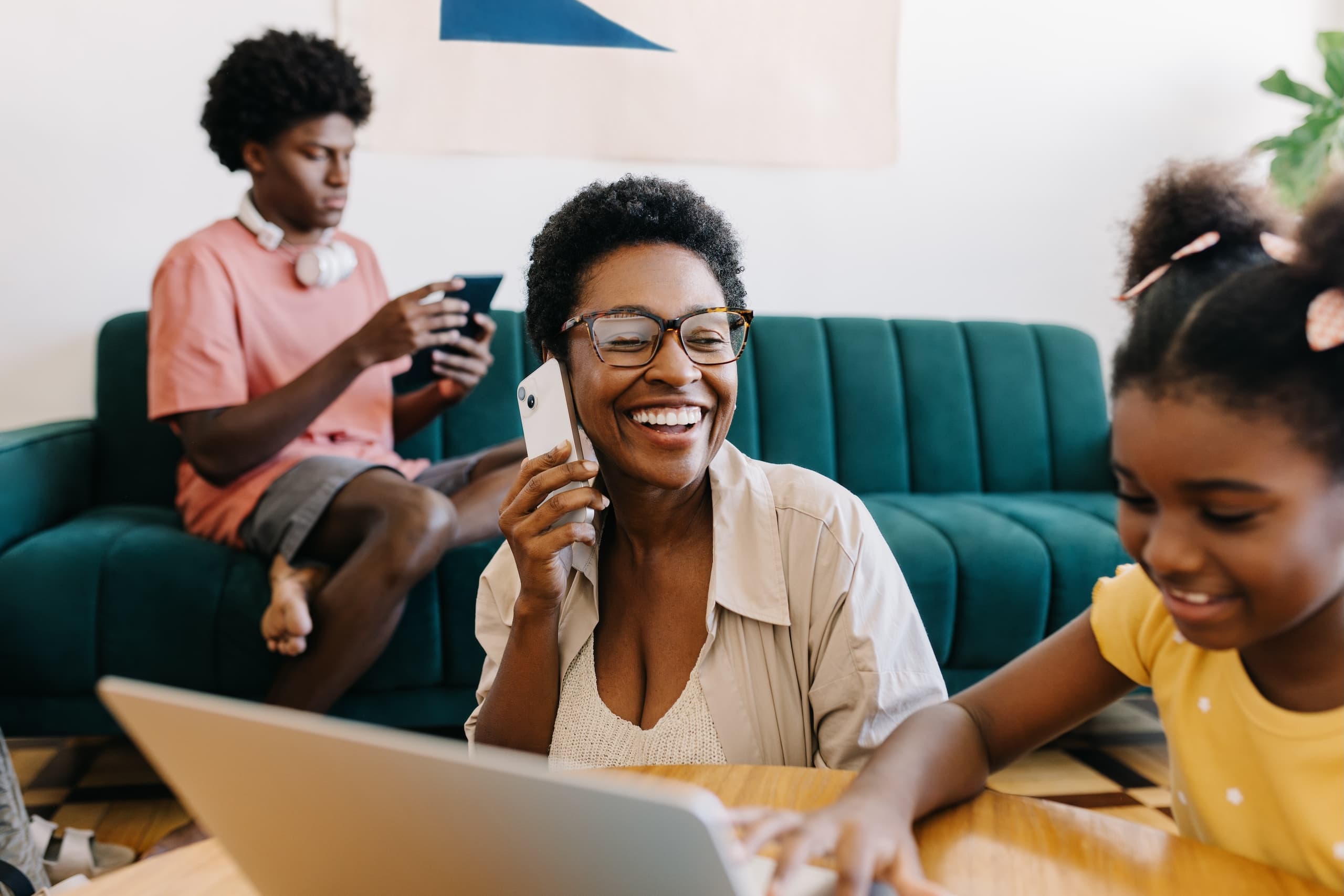 blog/Woman smiles on the phone while daughter uses computer and son browses on tablet