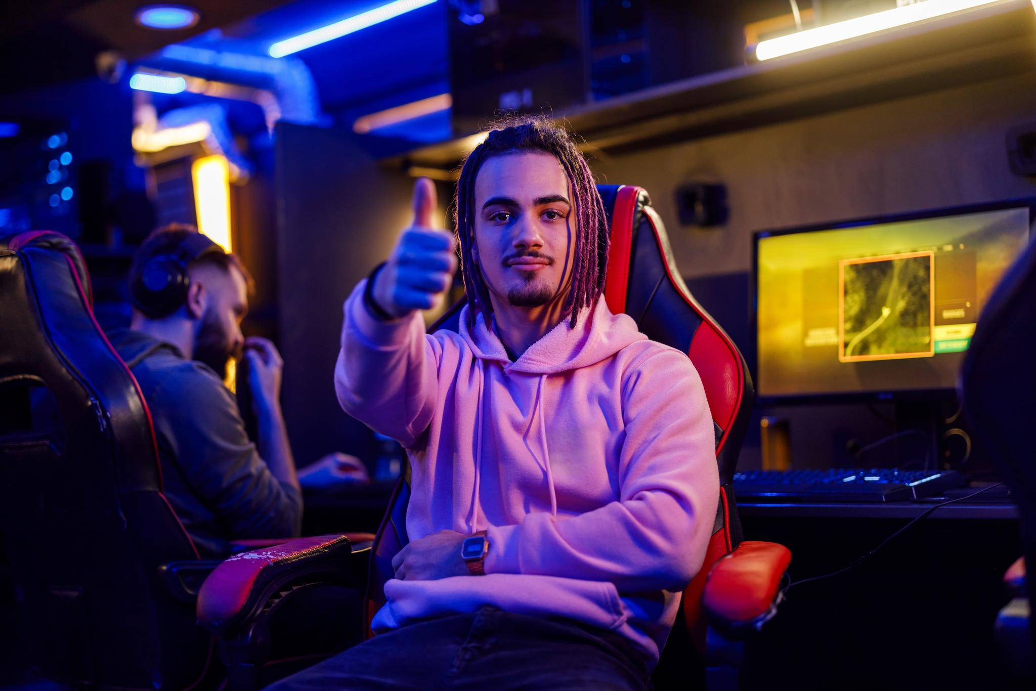 Gamer turns away from the computer monitor to give the camera a thumbs up