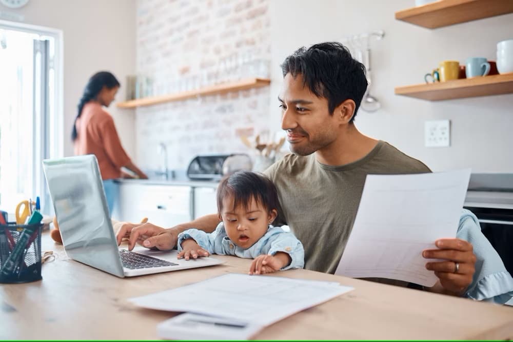 Dad working home laptop family baby wife