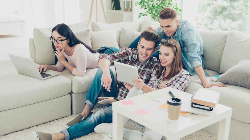 A group of young adults use wireless devices to access the internet