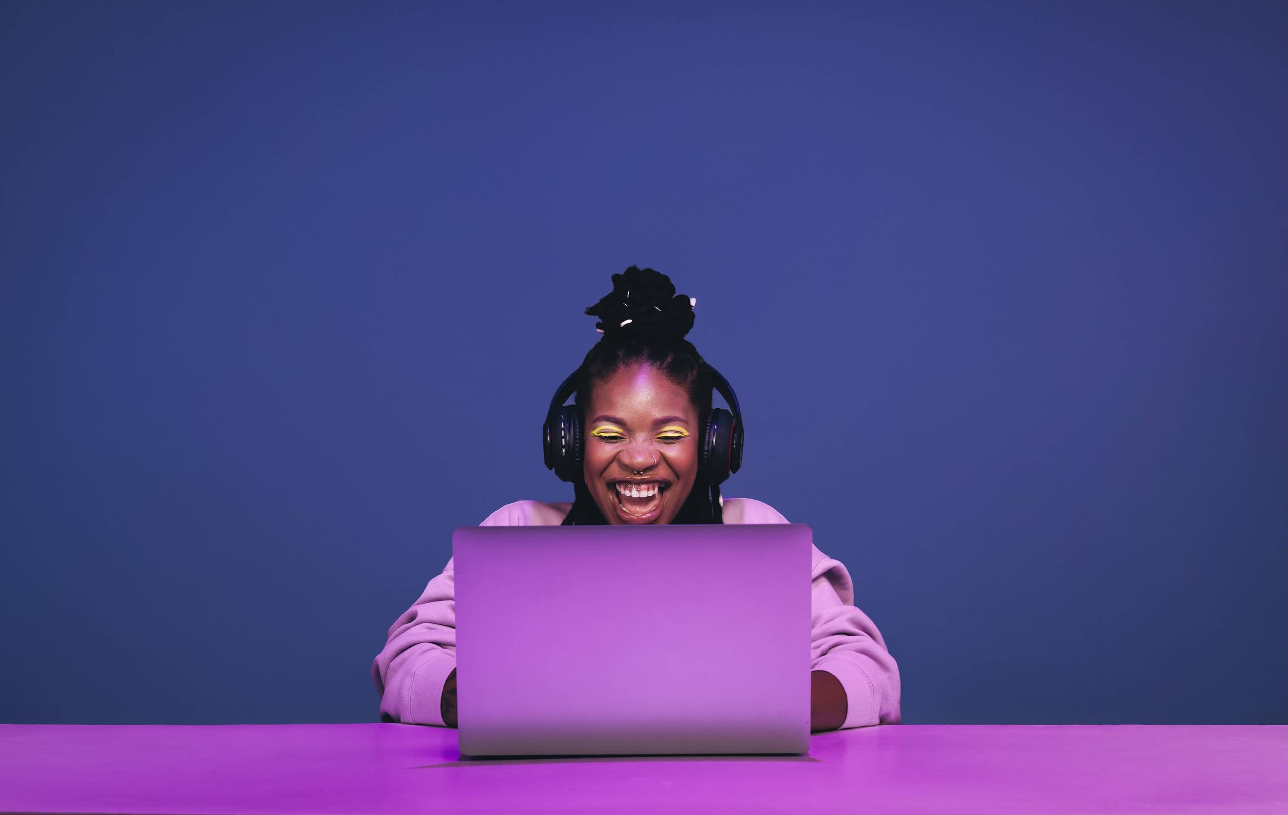 blog/Cheerful woman smiles while gaming on a purple laptop.png