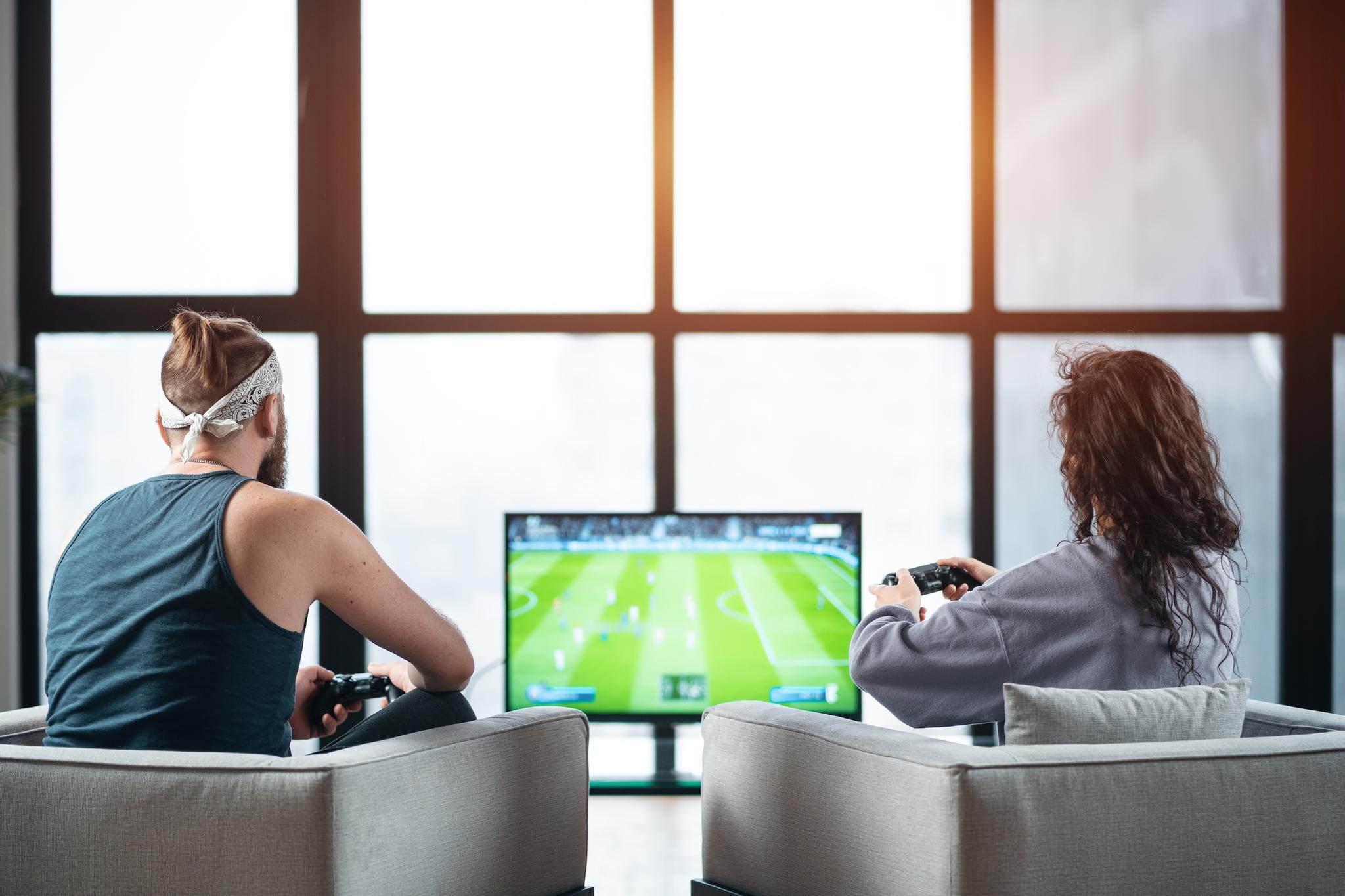Couple plays a sport game on a gaming console