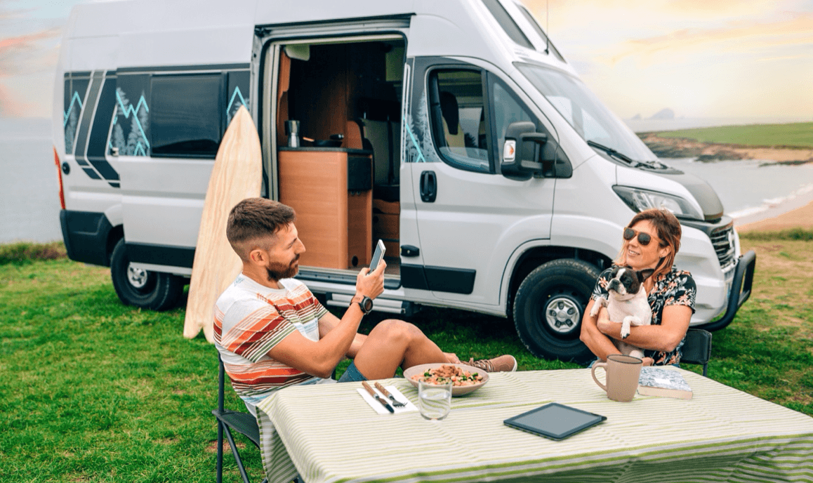 blog/Couple eats dinner outside their camping van on a secluded coastline.png
