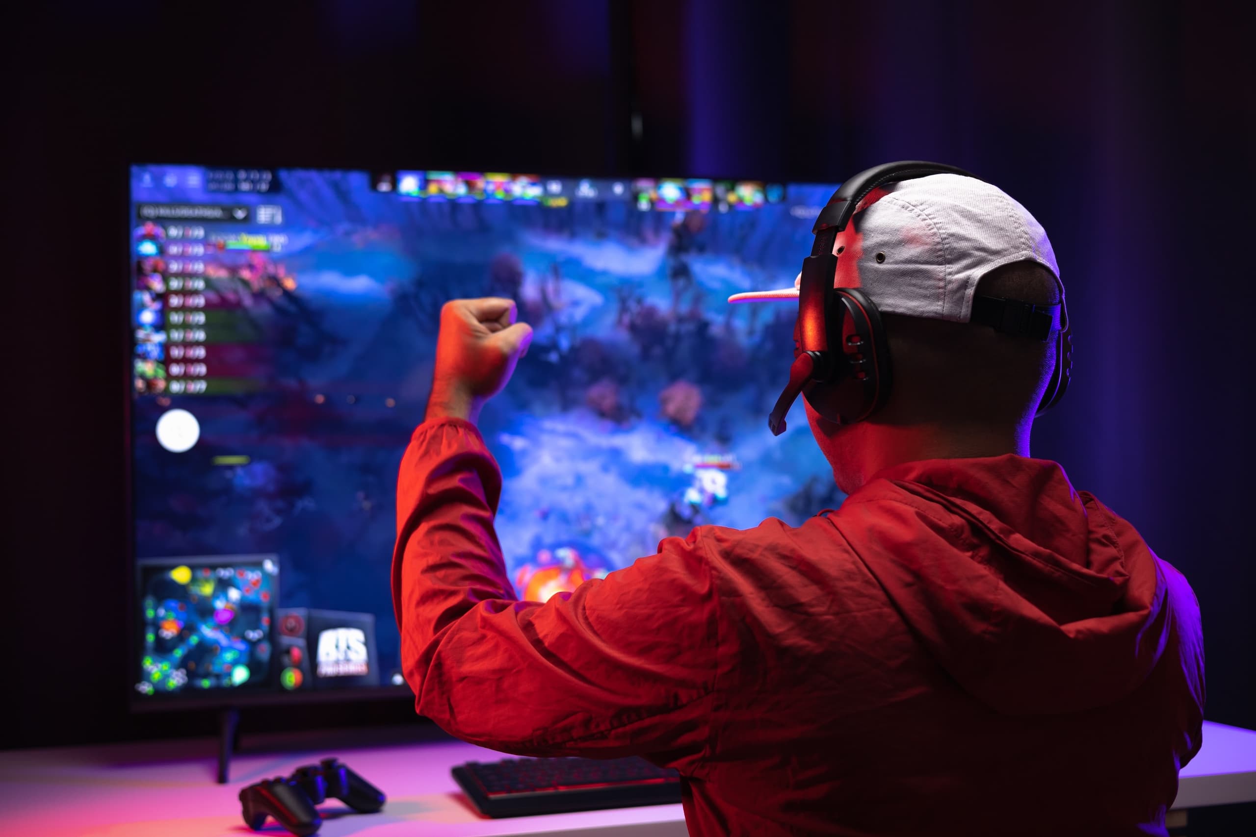 blog/Gamer puts hand up in victory while playing an online game