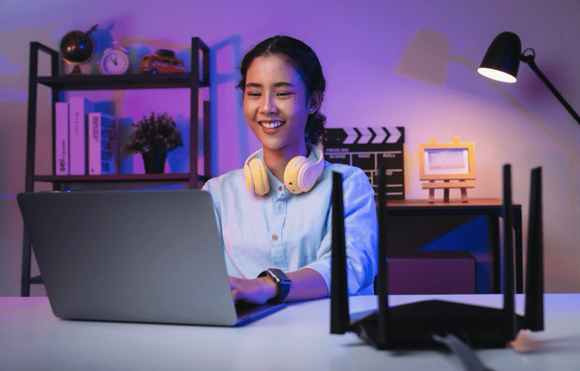 blog/Happy woman types on keyboard with router in foreground.png