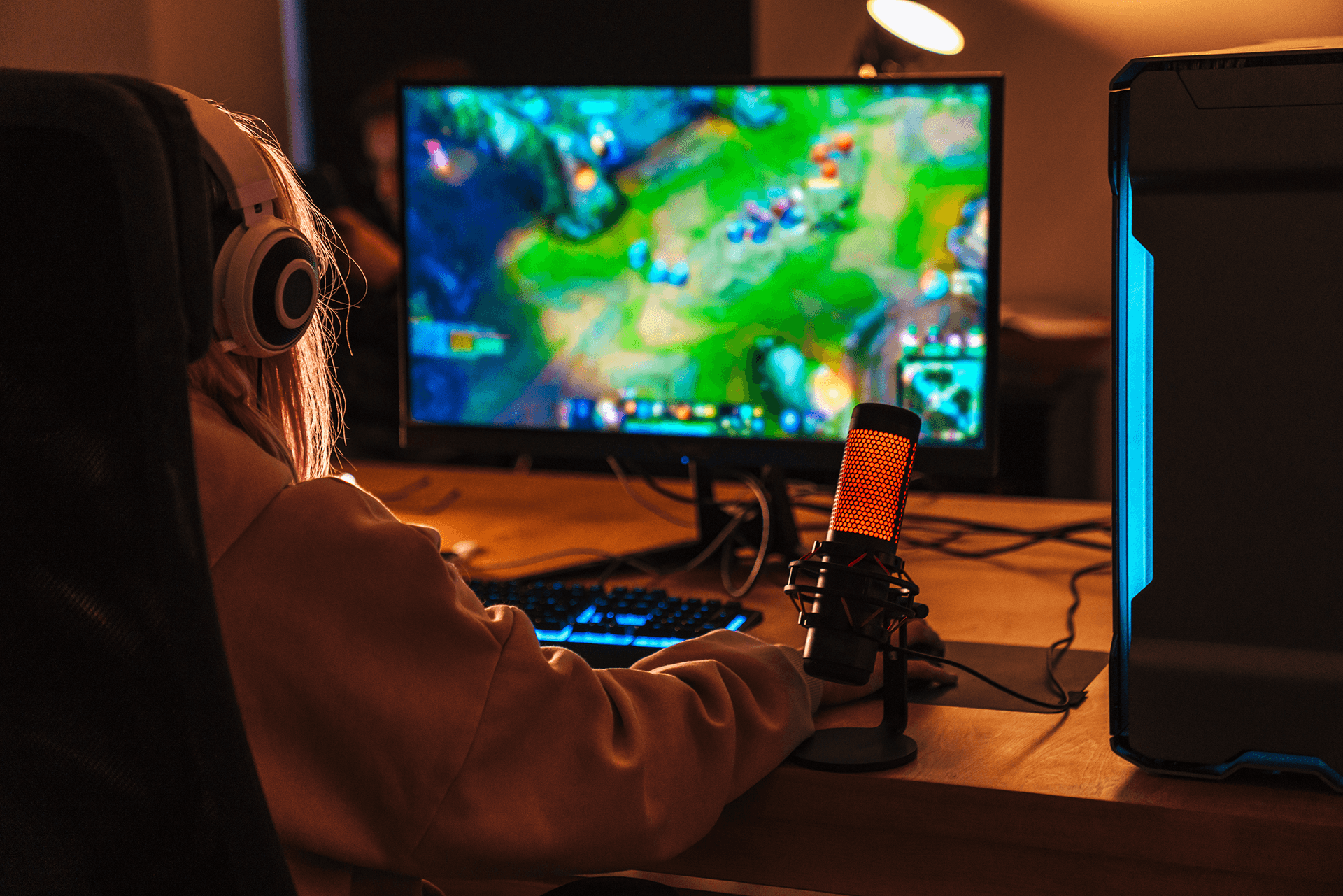 Image from back of girl playing video game on personal computer
