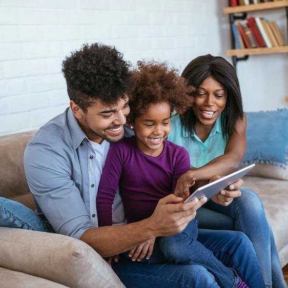 Parents and child enjoy internet together using a tablet via WiFi