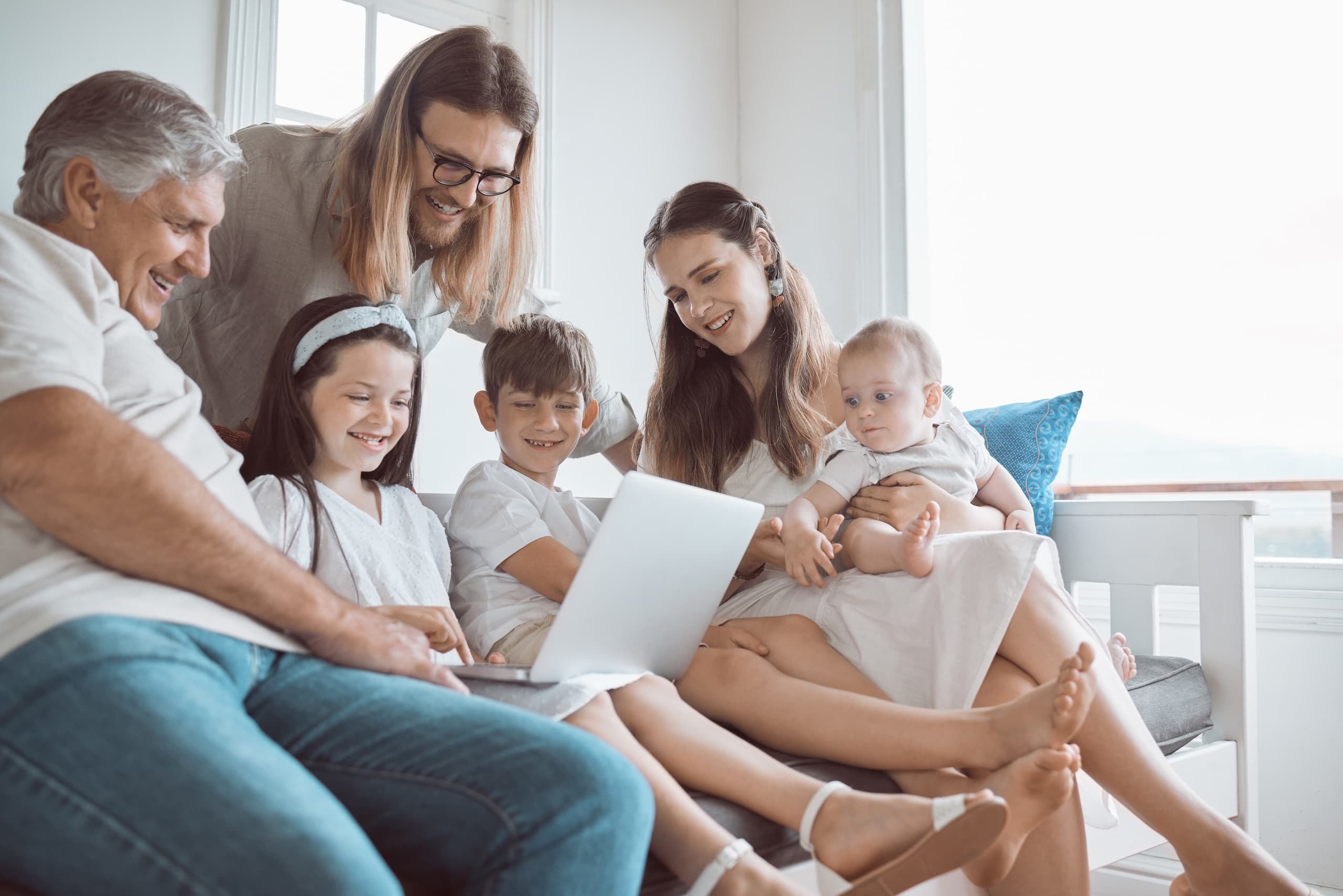 blog/Happy family sits on a couch and watches something on a laptop