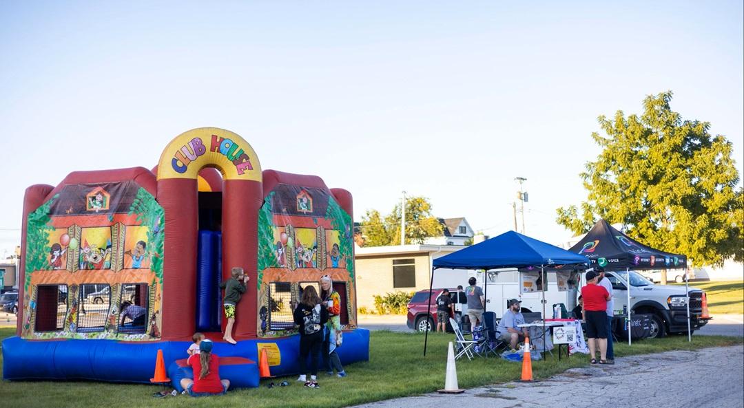 People enjoying bounce houses at a Kinetic Internet local event.
