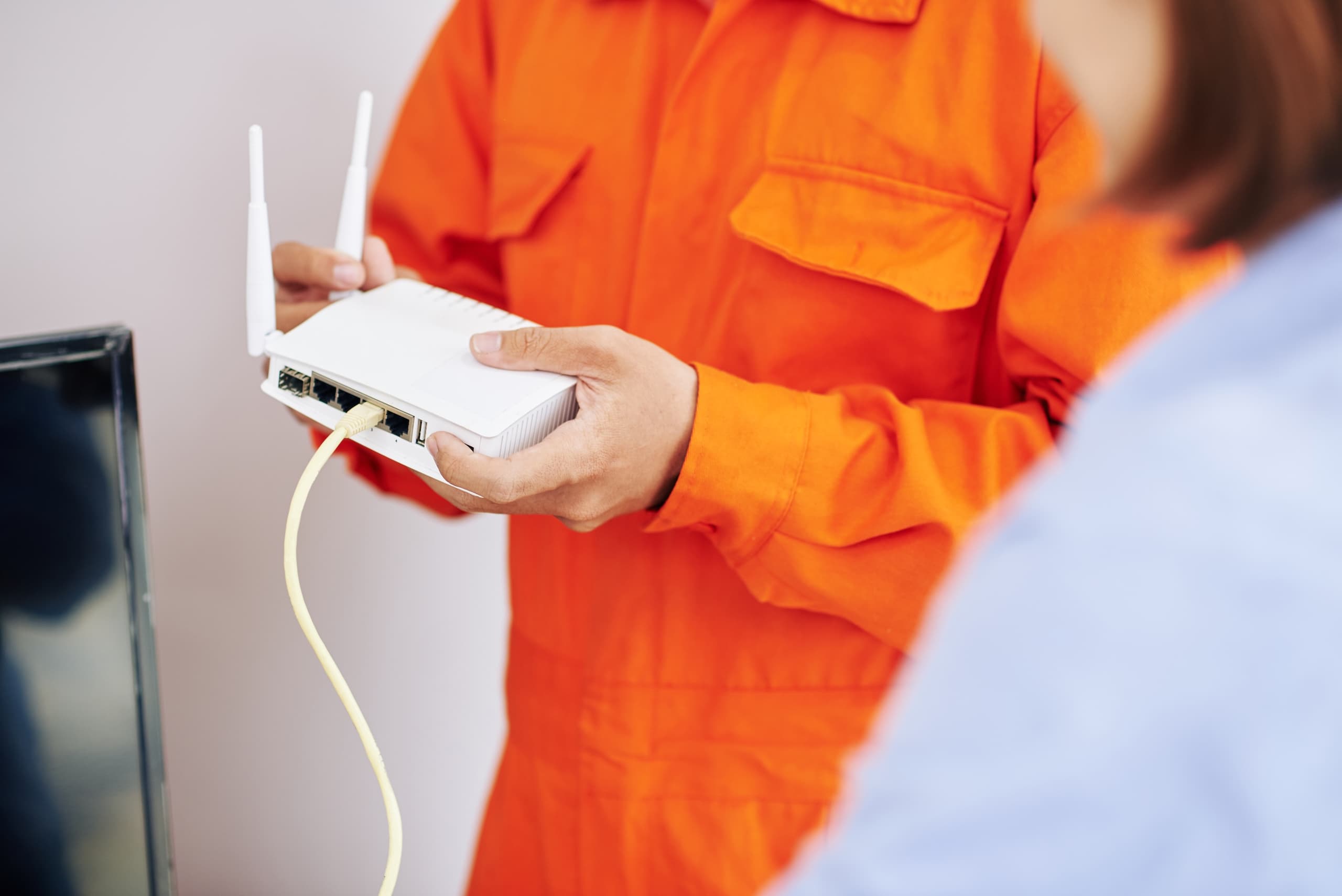 Technician holds router with cable and pushes button