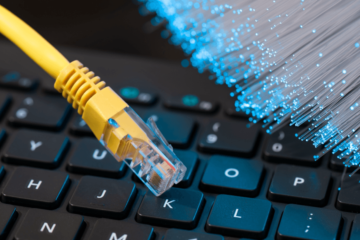 blog/Internet cable next to fiber optic strands on top of a keyboard.png