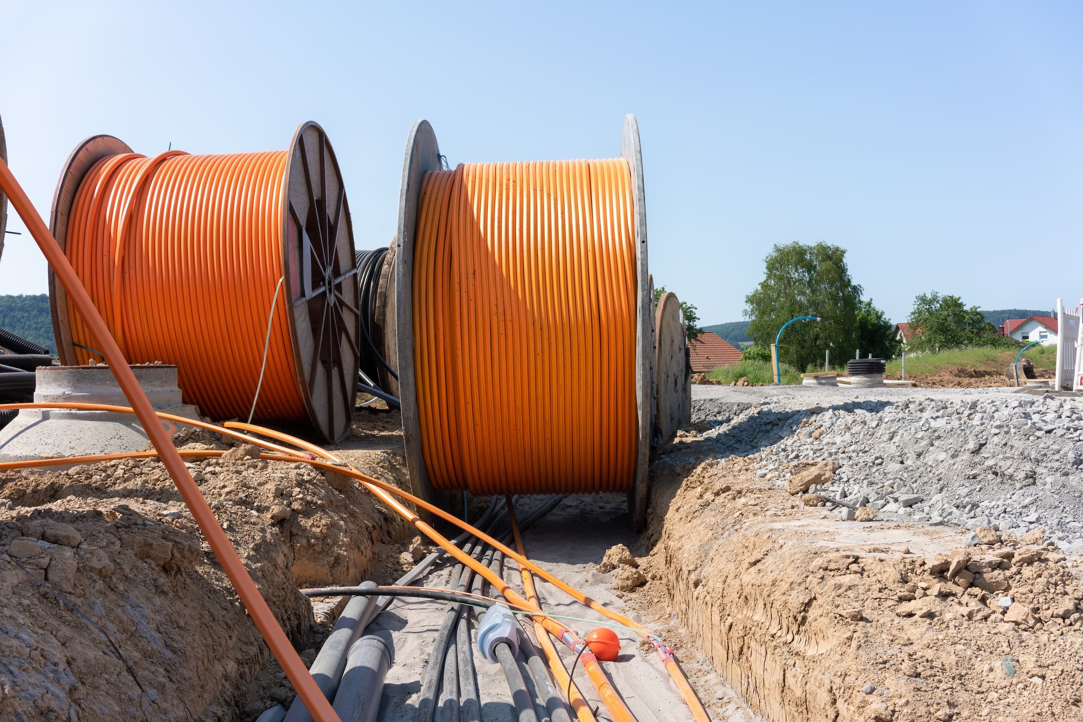 blog/Large coils of broadband internet cable being laid in a trench in the ground.