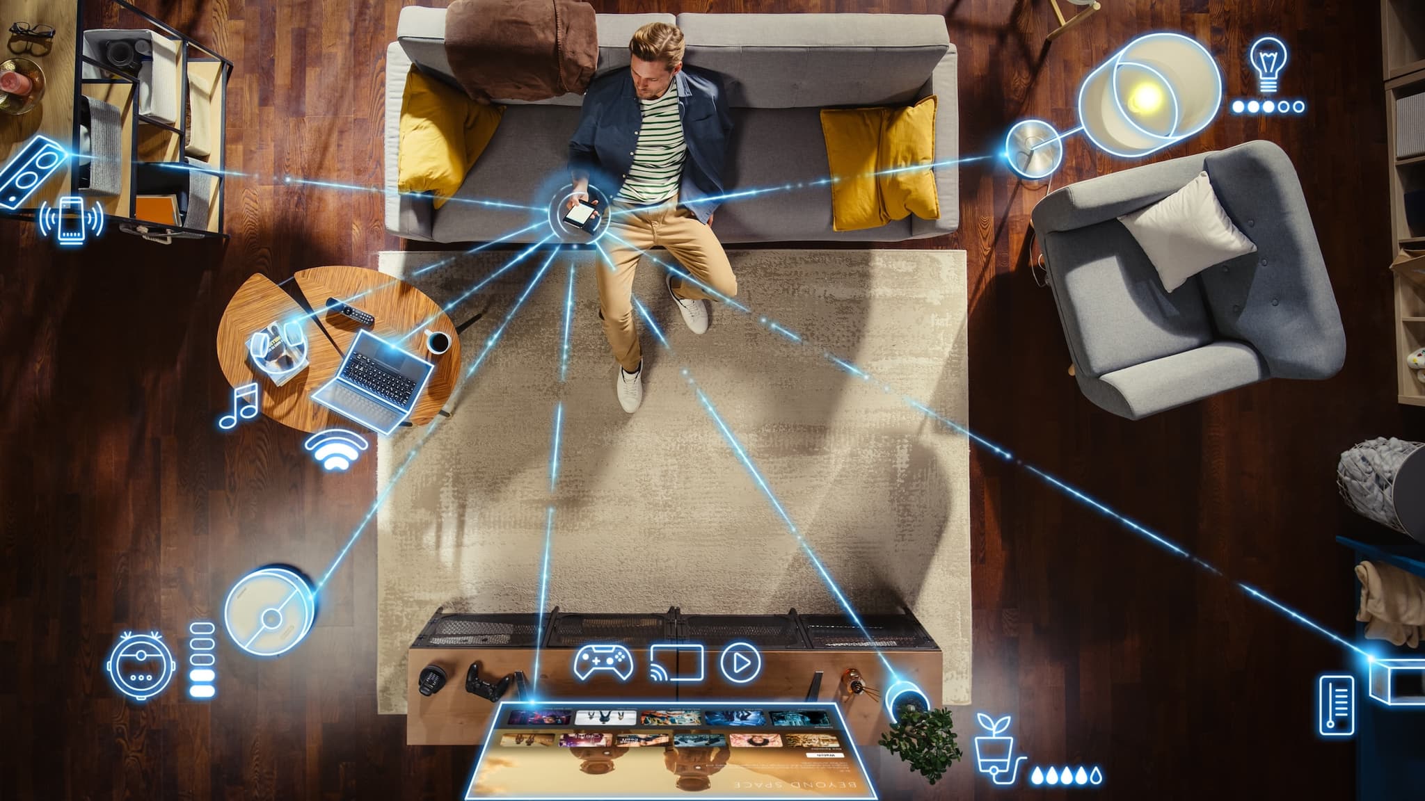 Man on couch holds phone that connects to other smart devices via Wi-Fi